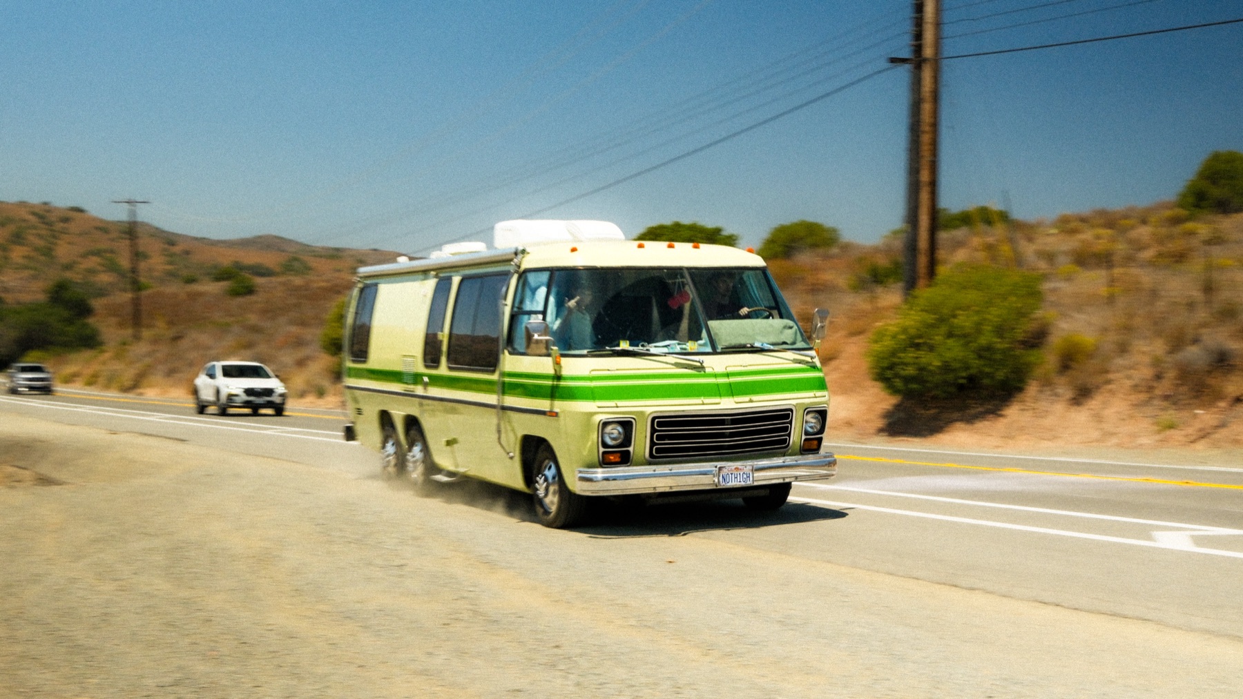 The green RV pulling onto a Southern California road