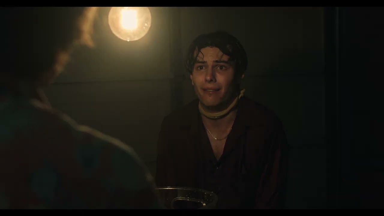 A frightened captive facing his interrogator in a dim room in Waterboarder